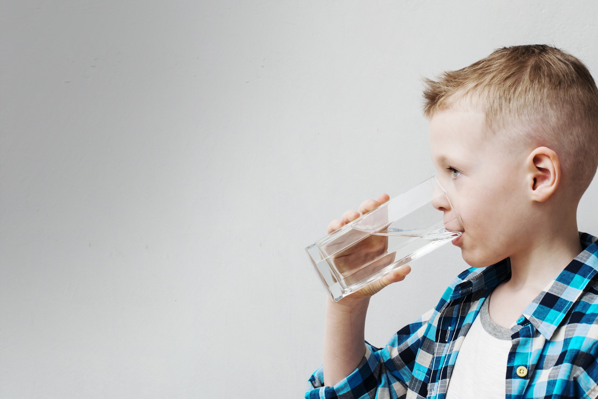 Kid drinking water out of a glass