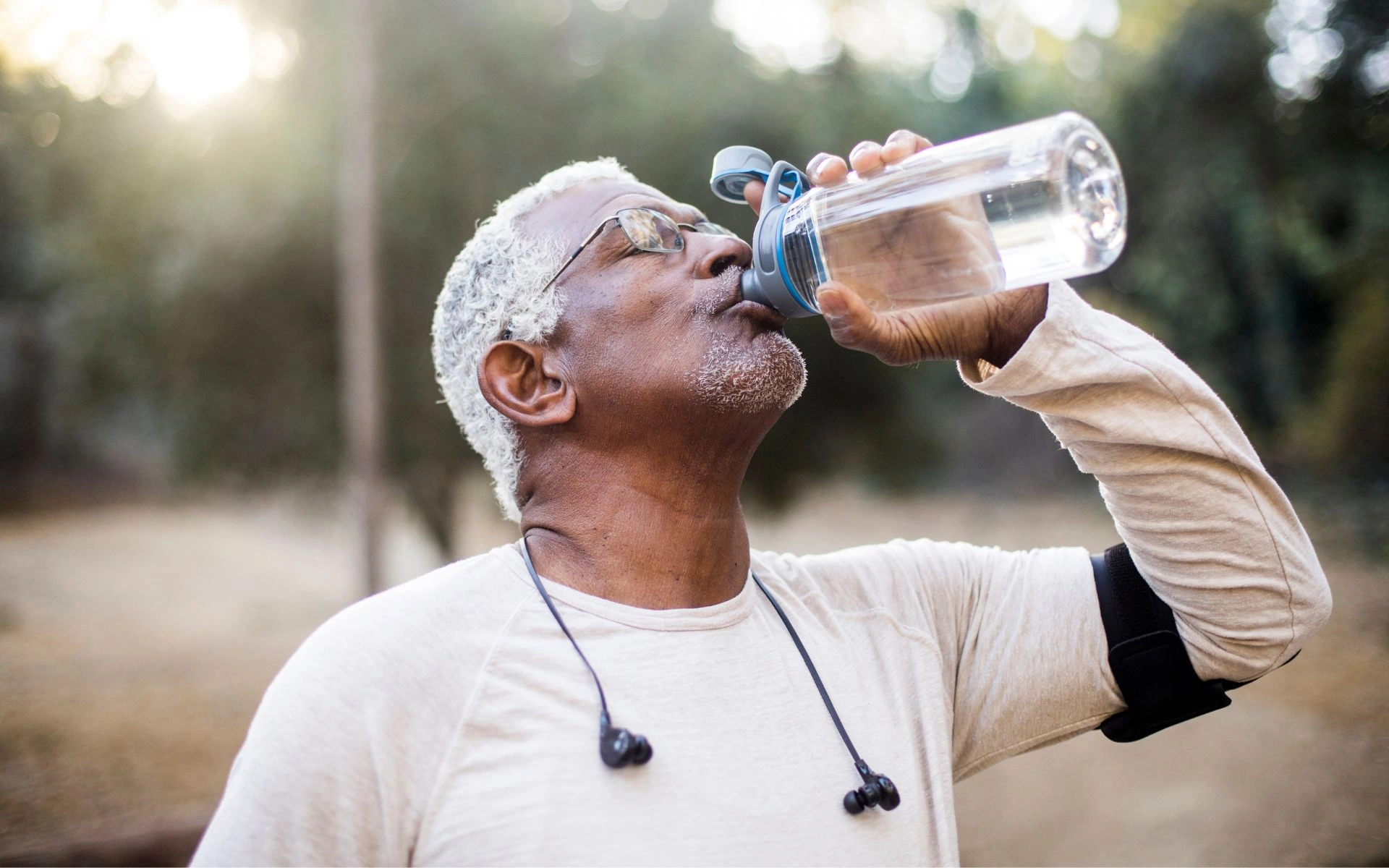 Older man drinking water outdoors, representing clean drinking water and home water quality in New Hampshire